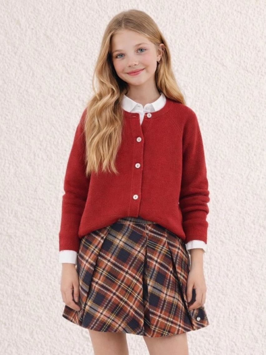 Child wearing red cardigan white collar and plaid skirt