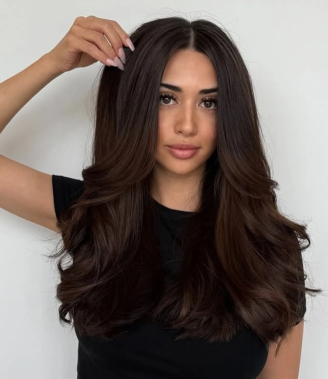 Mid-long dark chocolate brunette hair with soft face layers