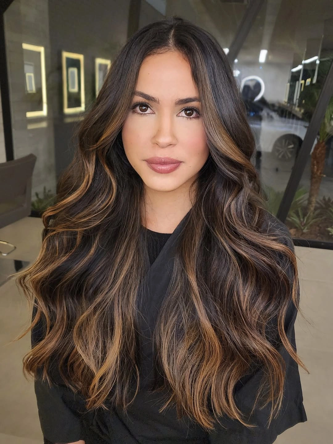 Long center-part brunette waves with strong caramel highlights