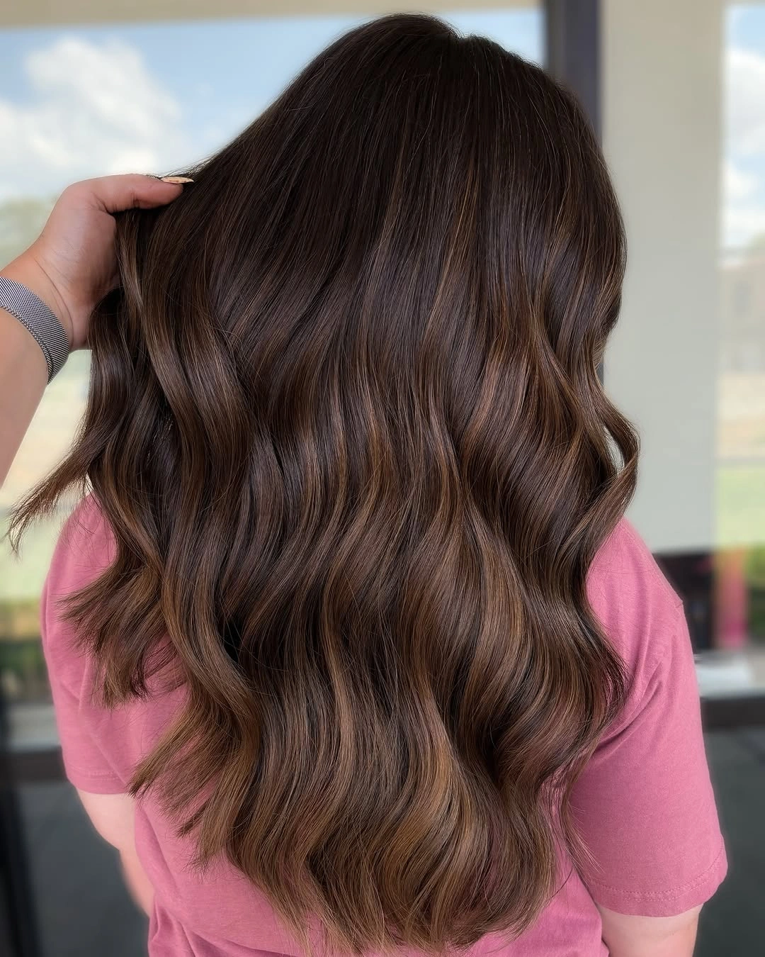 Back view of long brunette waves with subtle warm dimension