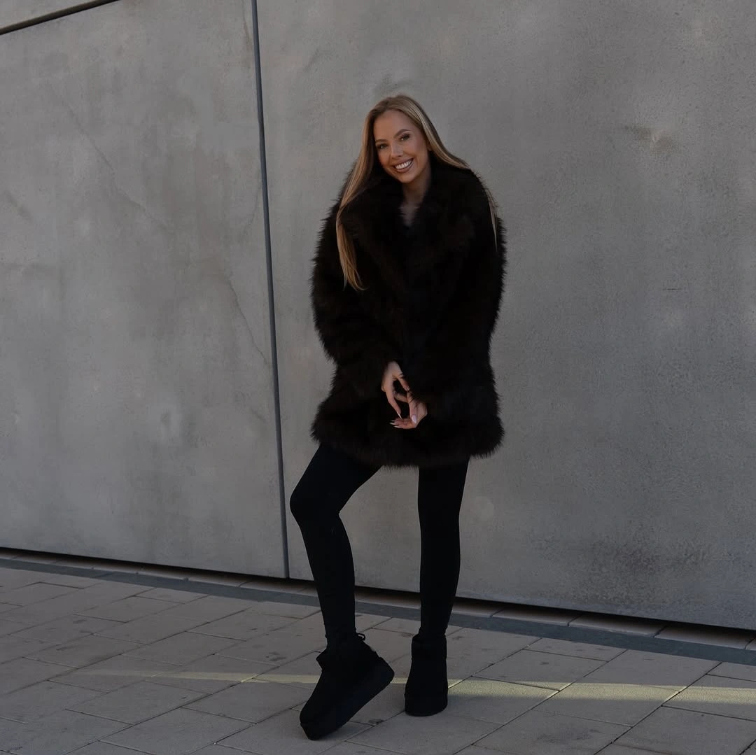Short black shaggy coat with black leggings and black heeled boots