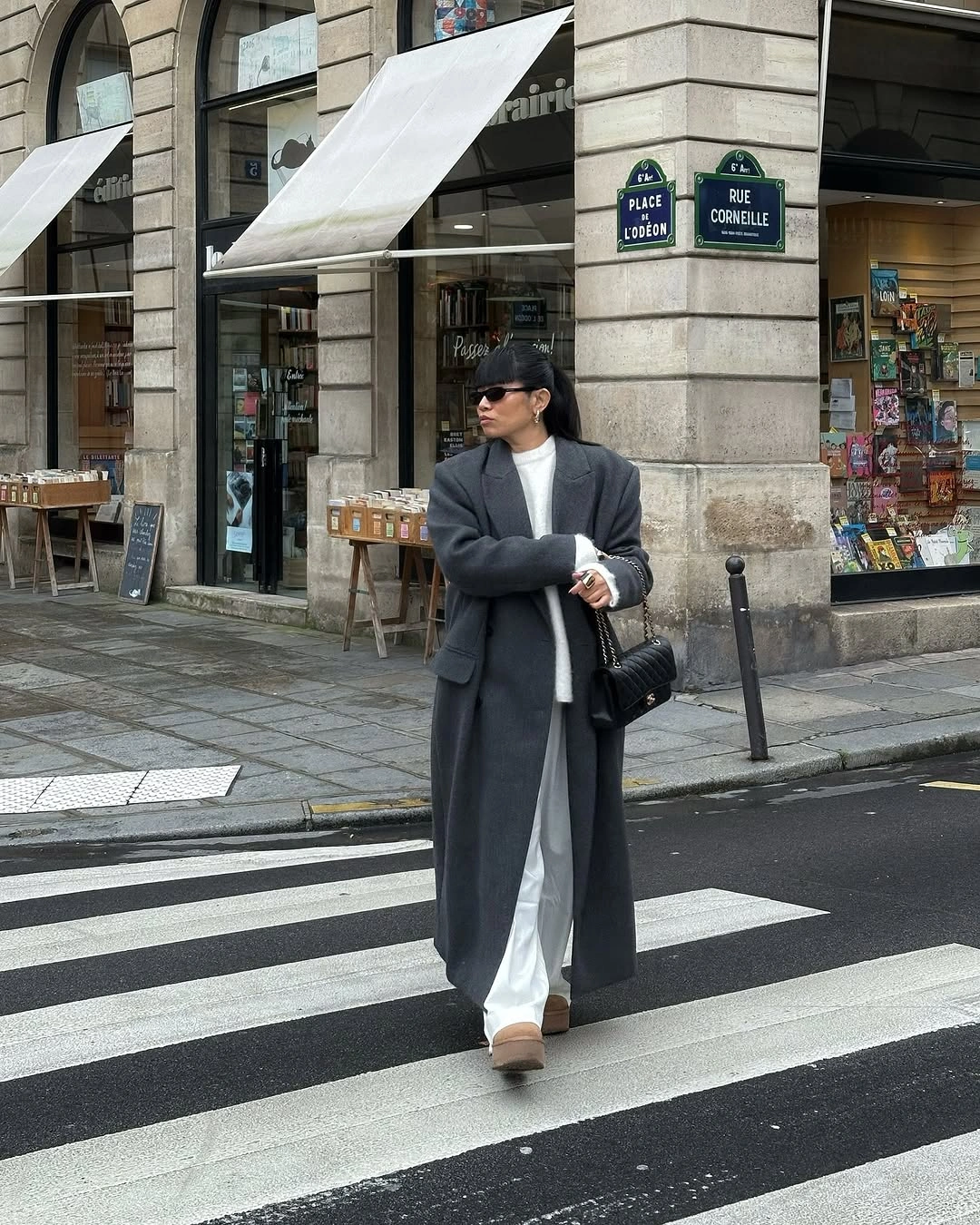 Long charcoal coat over white knit and wide trousers with tan shoes