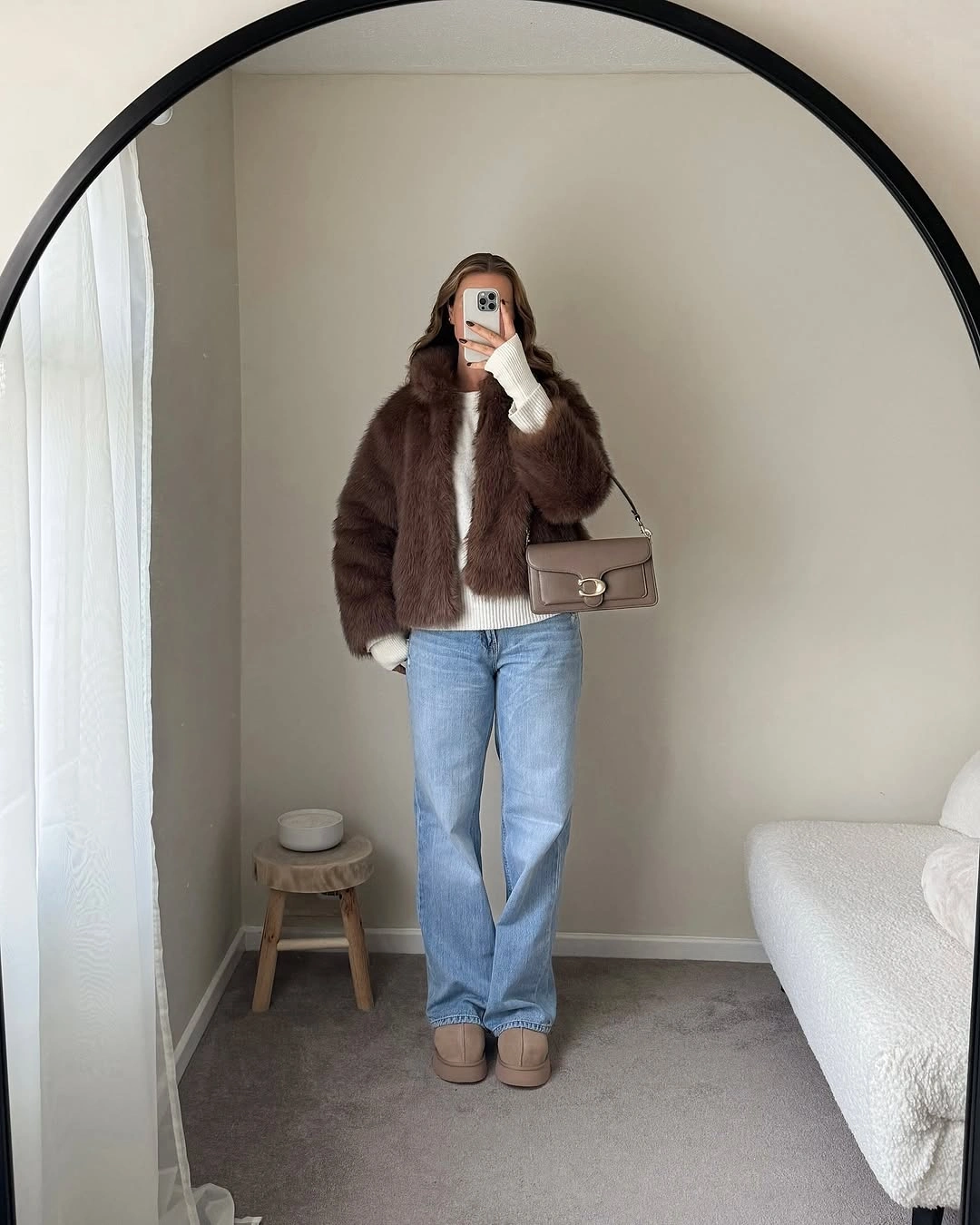 Dark-brown plush jacket over cream knit with blue jeans and tan shoes