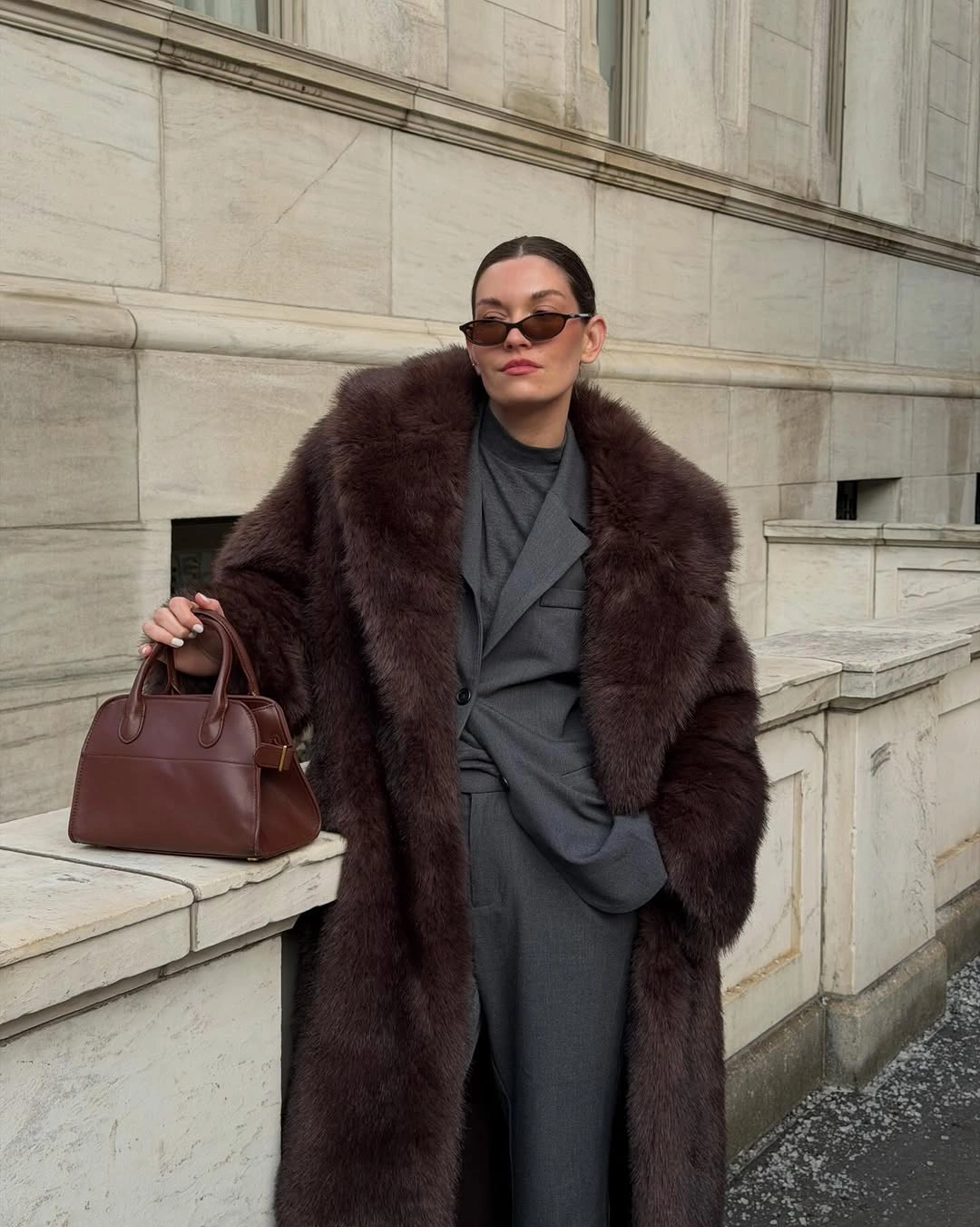 Deep-brown textured coat over gray tailoring with structured brown handbag