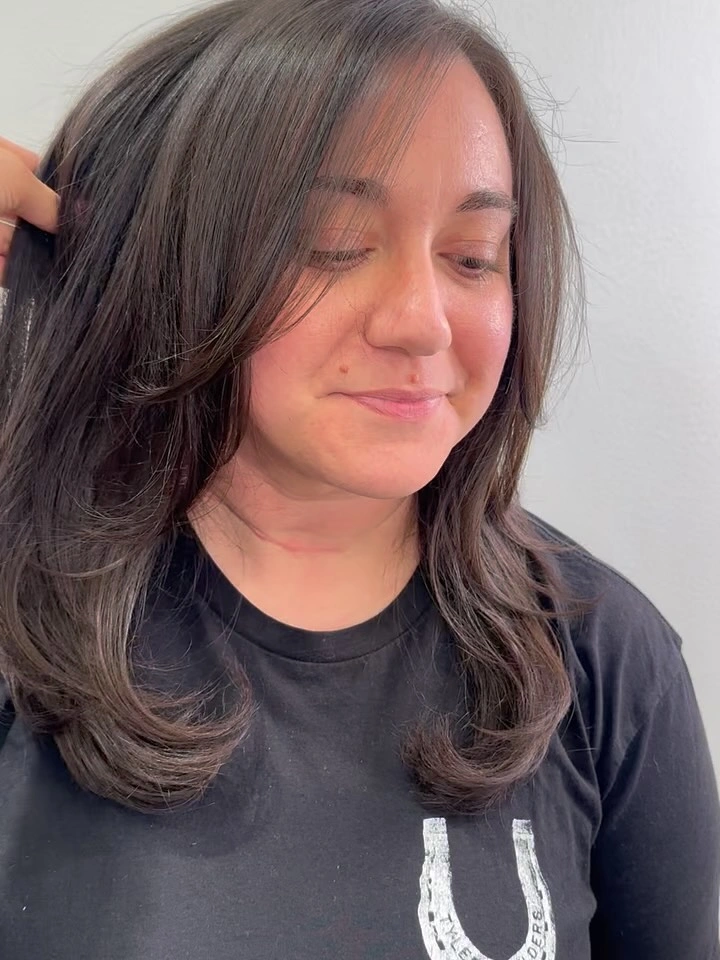 Dark medium haircut with side-swept face-framing layers