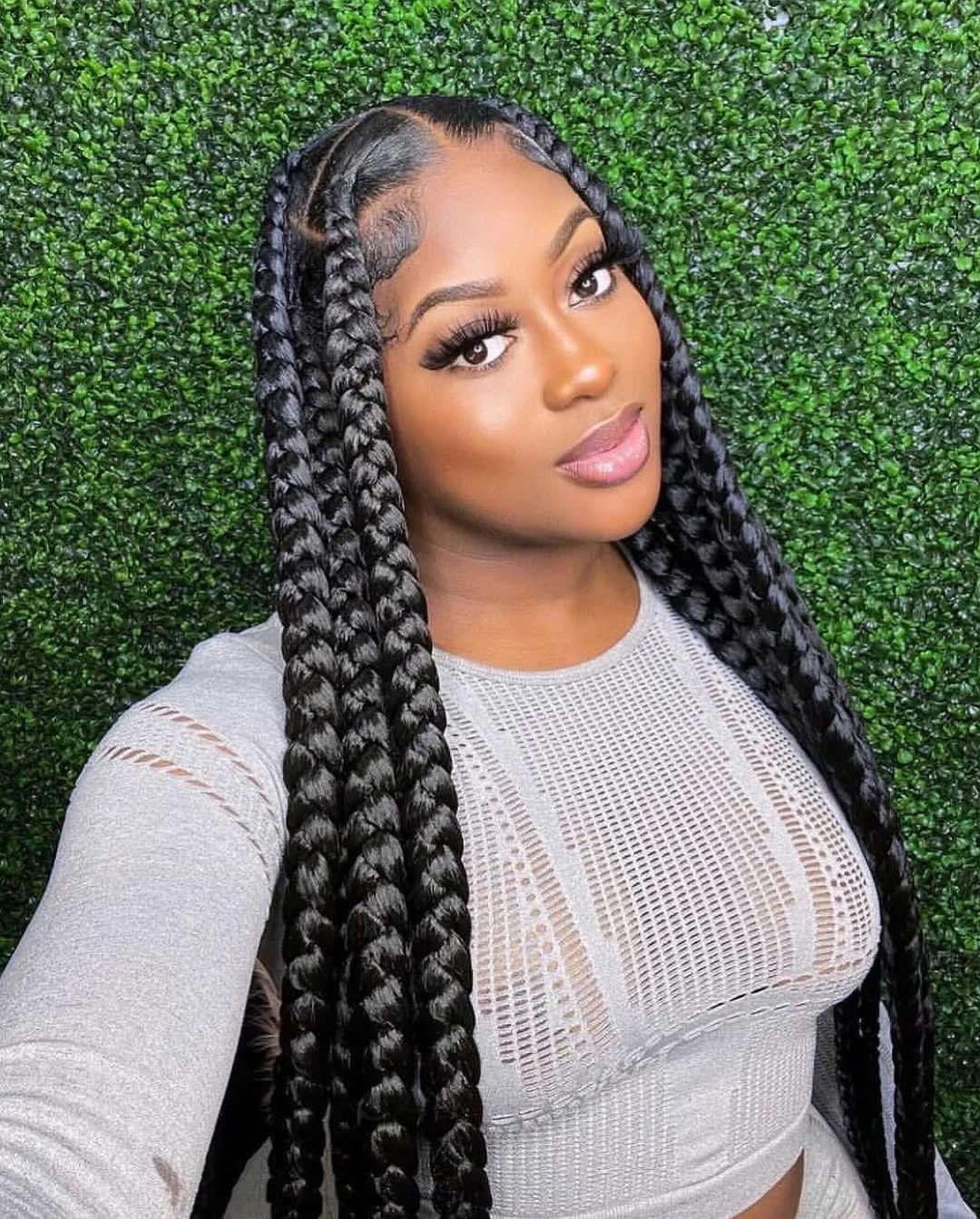Long black braids with center part and glossy finish