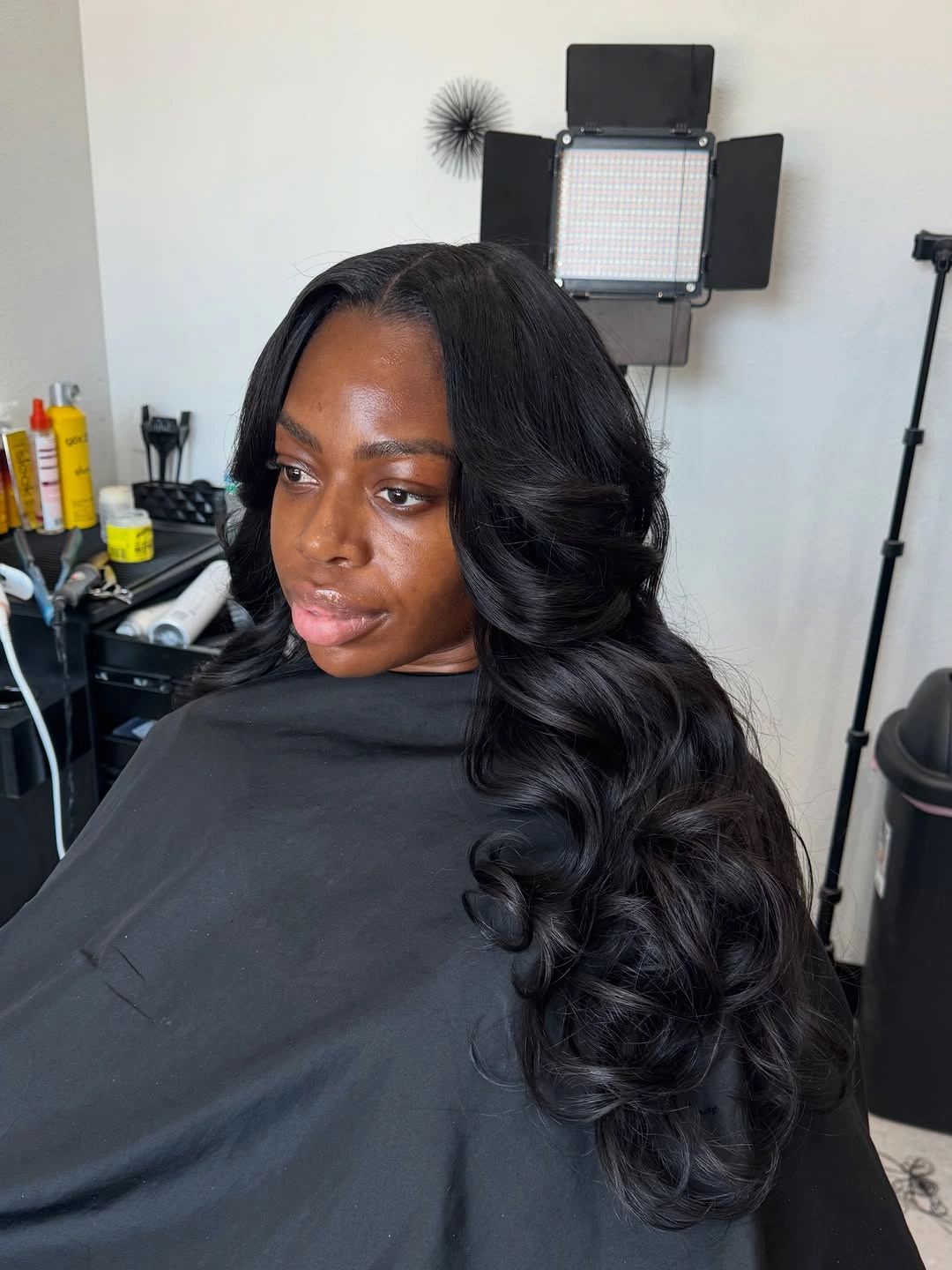 Long black waves with deep side part and glossy finish