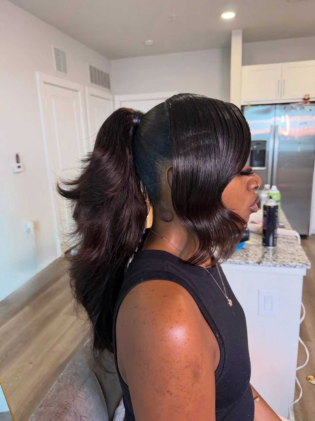 Smooth black hair with side sweep and lifted back ponytail
