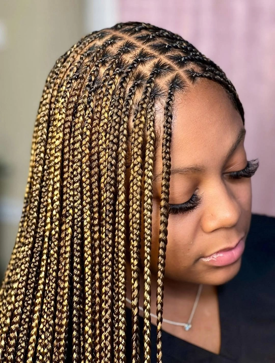 Long warm blonde and brown small braids viewed from side