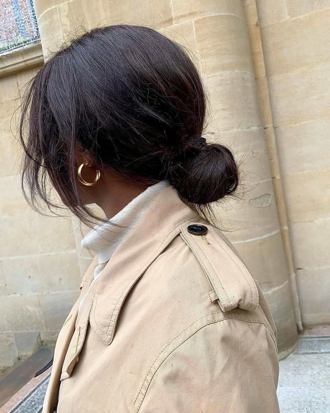 Low dark bun with loose face framing pieces