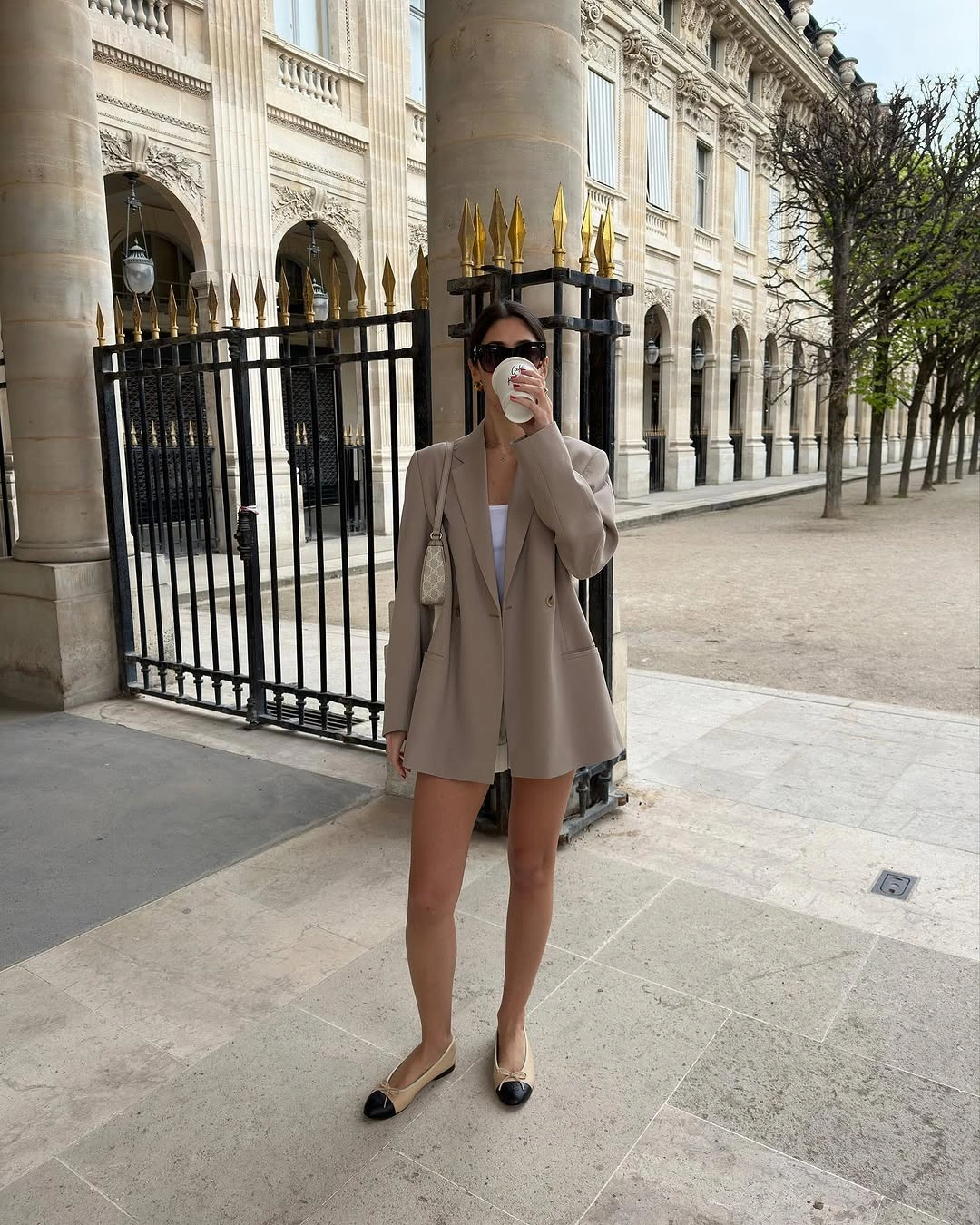 Taupe long blazer with white top, beige flats, and light bag