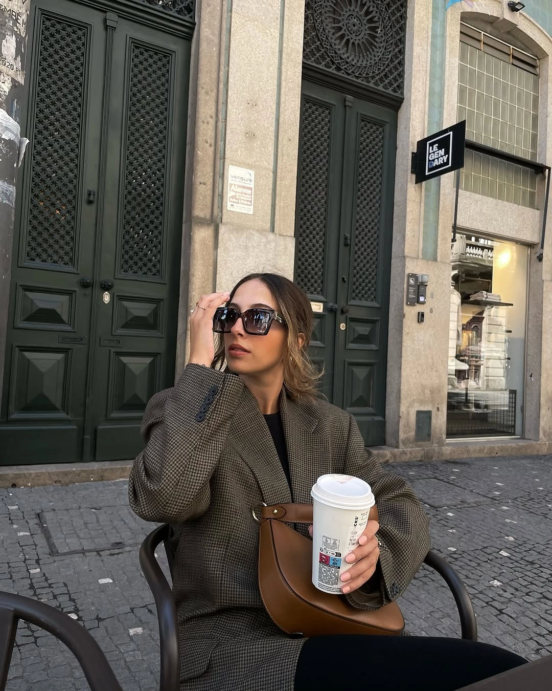 Micro-check blazer over black layers with brown crescent bag