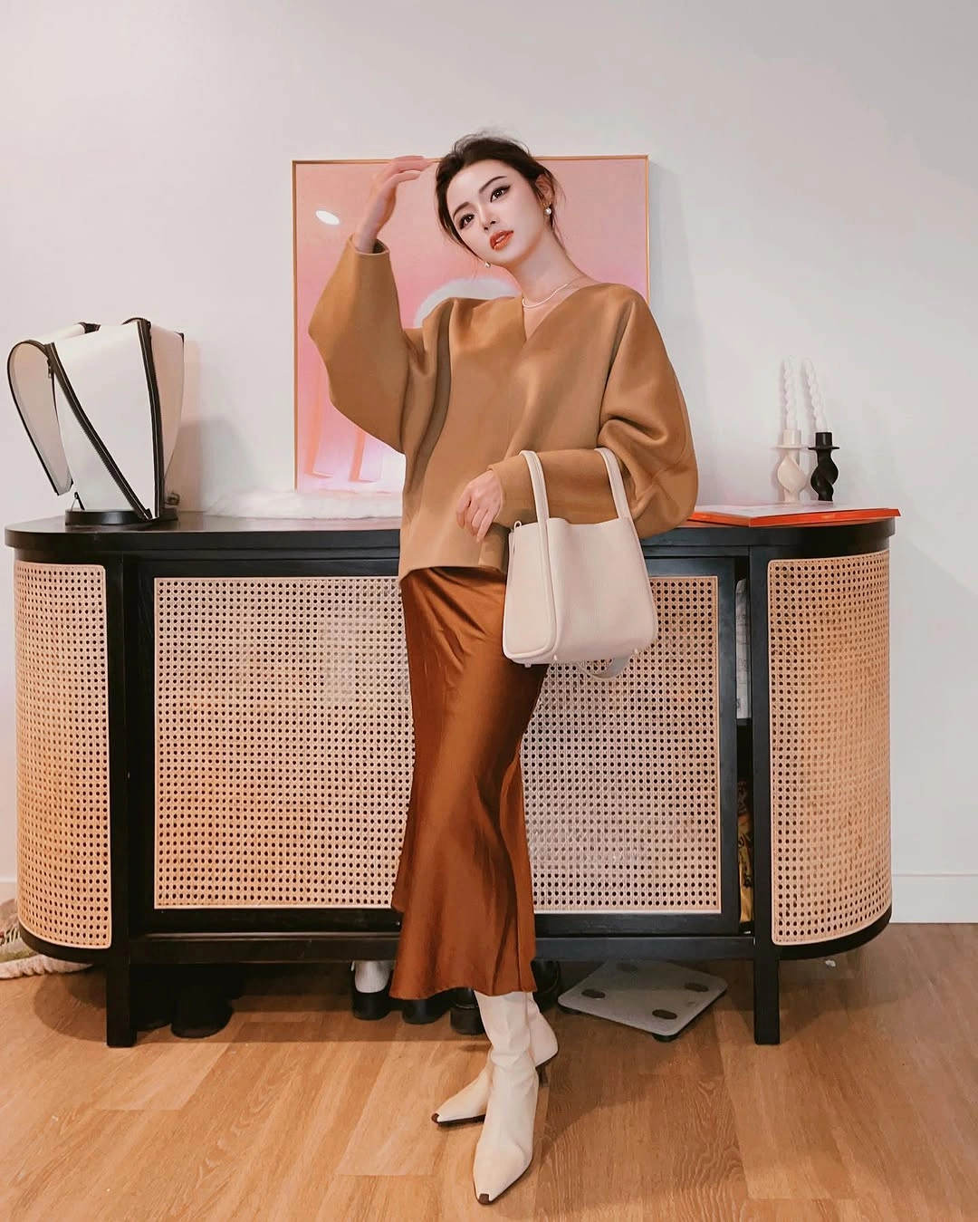 Camel-toned top with glossy-looking rust skirt, ivory boots, and tote