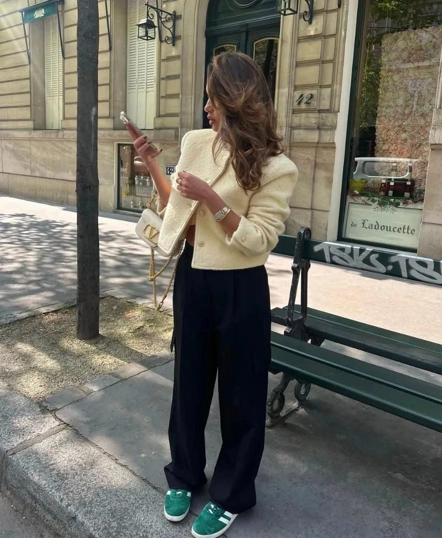 Cream cropped jacket, black wide-leg trousers, green sneakers, cream bag