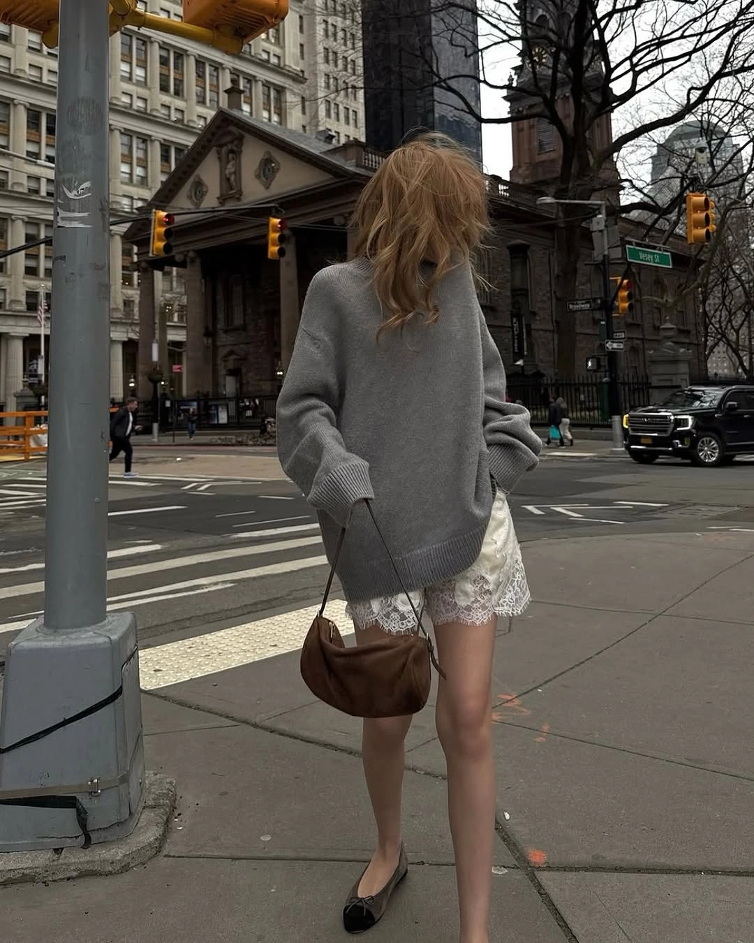 Long gray sweater over white lace-trimmed shorts with black flats