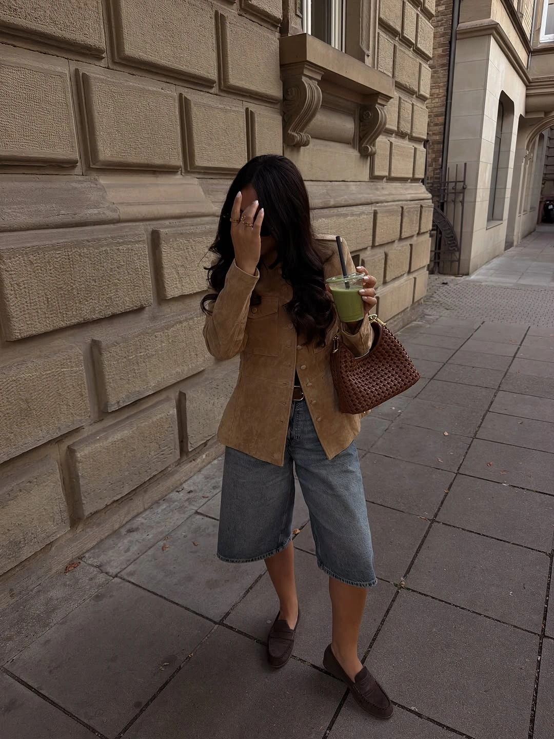 Tan button-front jacket with gray knee-length shorts and brown loafers
