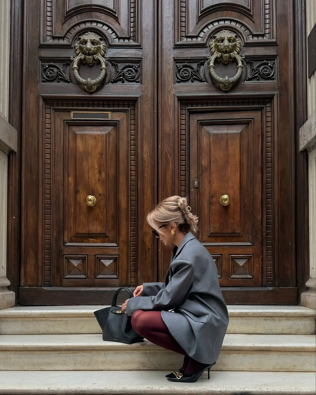 Charcoal oversized blazer with burgundy tights, black shoes, and tote