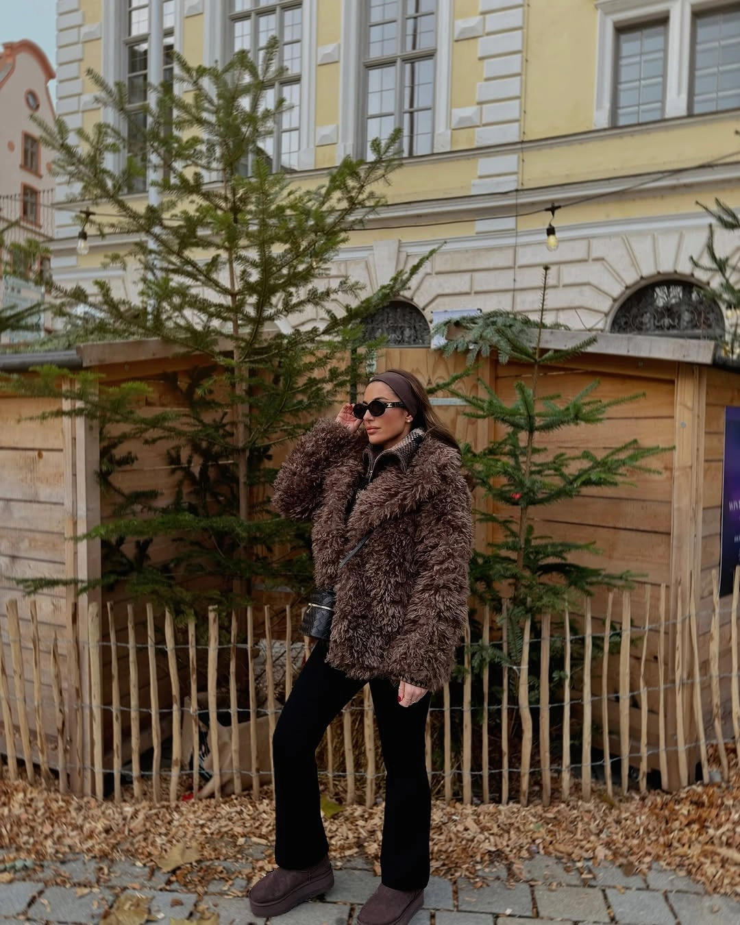 Woman in dark brown fuzzy coat and black flared trousers