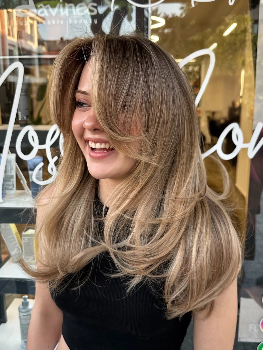 Long beige blonde hair with face-framing layers and curled ends