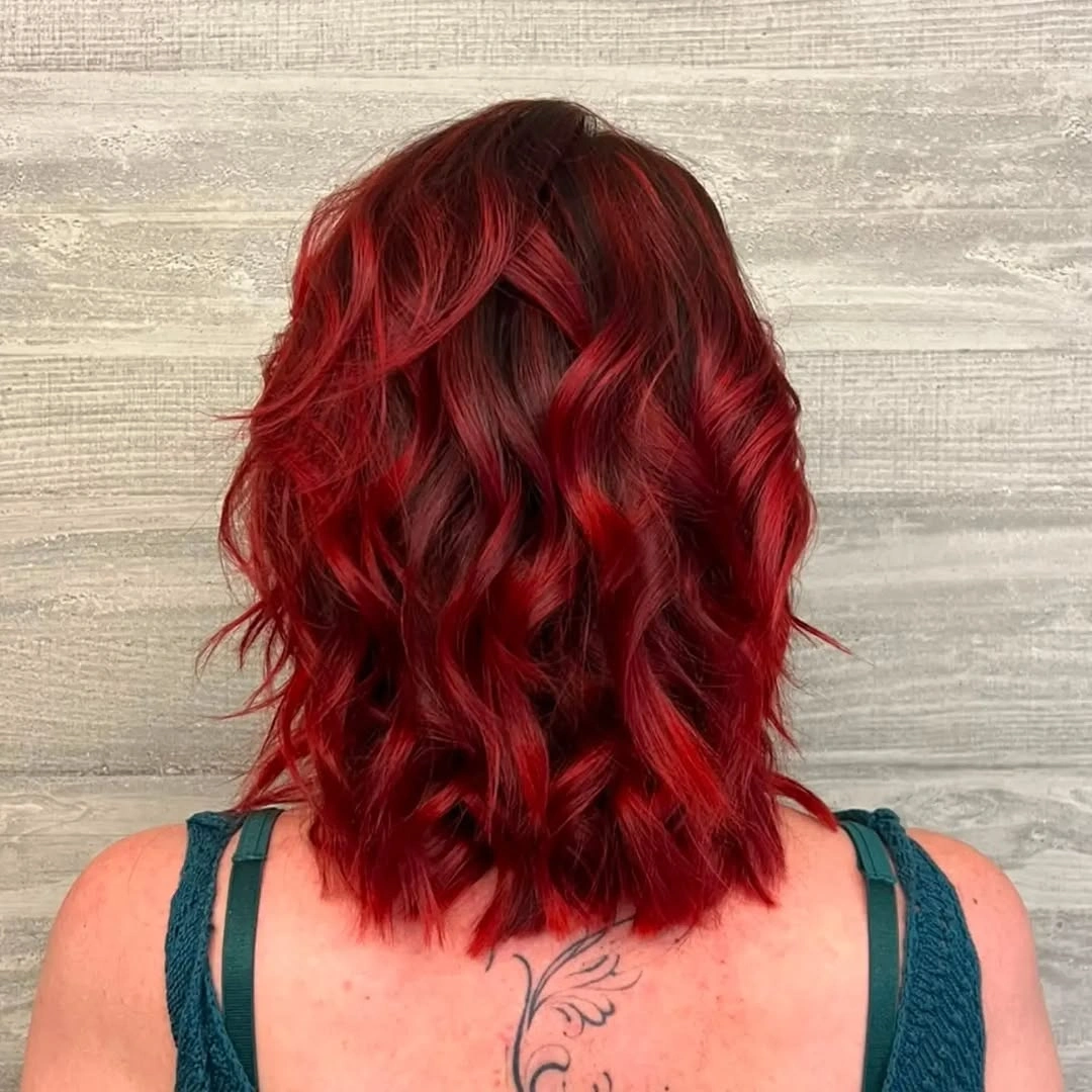 Shoulder-length wine red waves viewed from behind