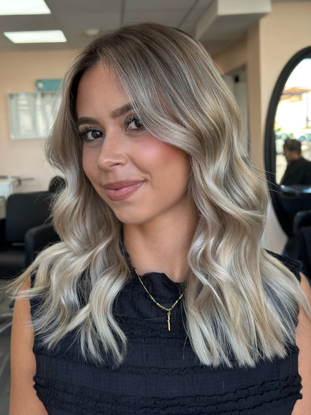 Shoulder-length silver blonde hair with center part and soft waves