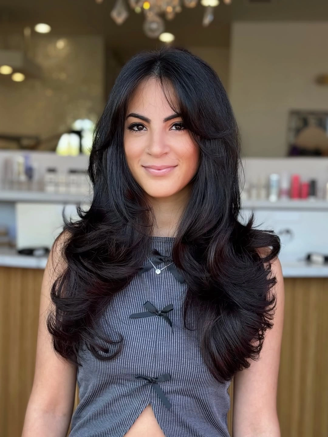 Long dark brunette layered cut with curtain bangs and rounded ends