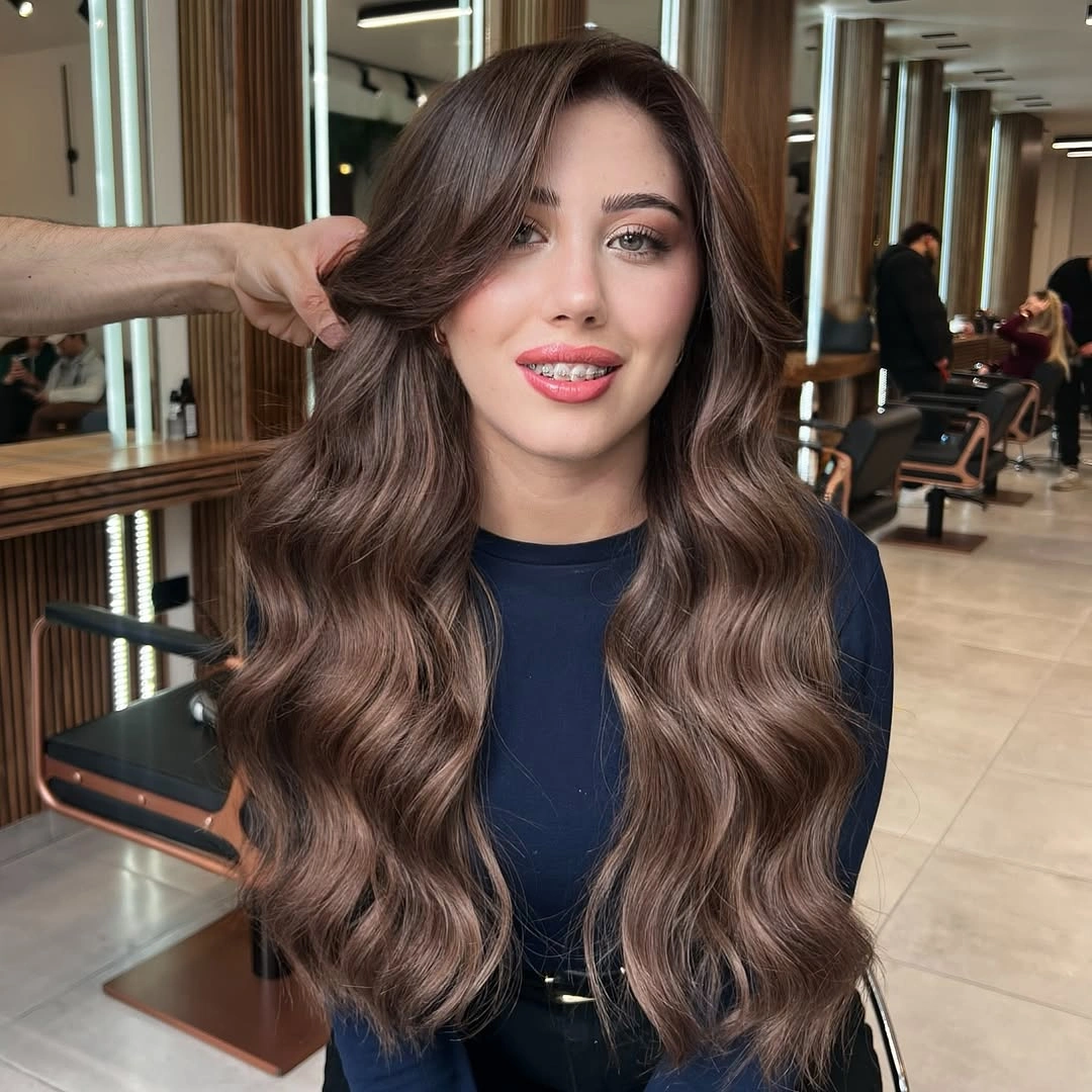 Long dark ash brown waves with side part in salon setting