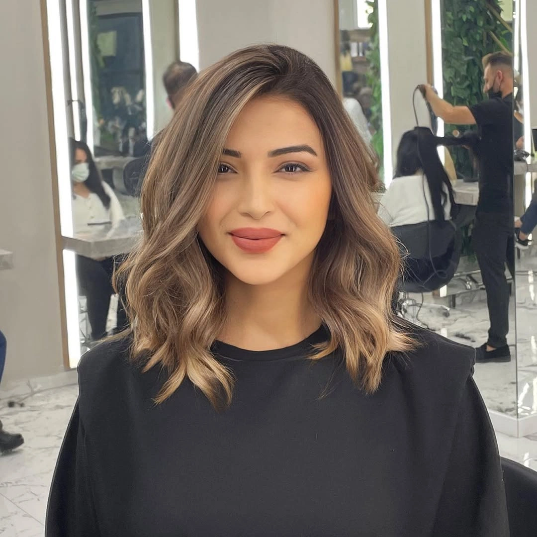 Beige bronde shoulder length waves with soft side-framed front layers