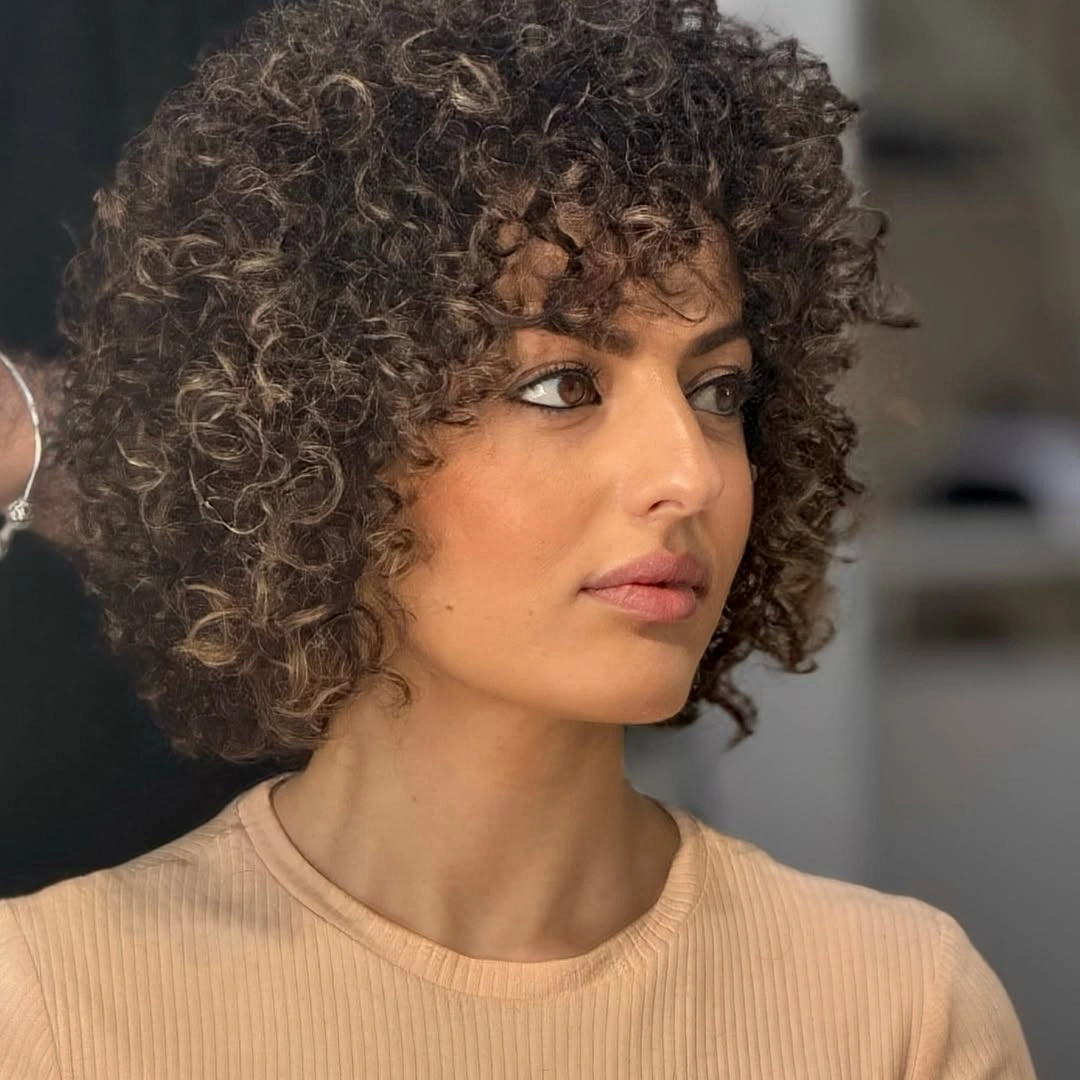 Short dark curly bob with rounded volume and curly fringe