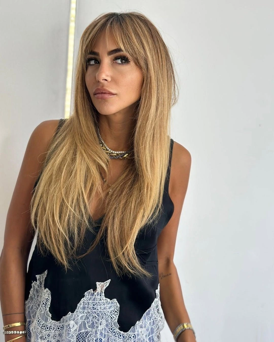 Long honey blonde hair with curtain bangs and tapered layered ends