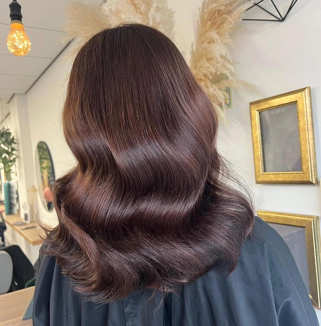 Medium long burgundy brown waves seen from the back
