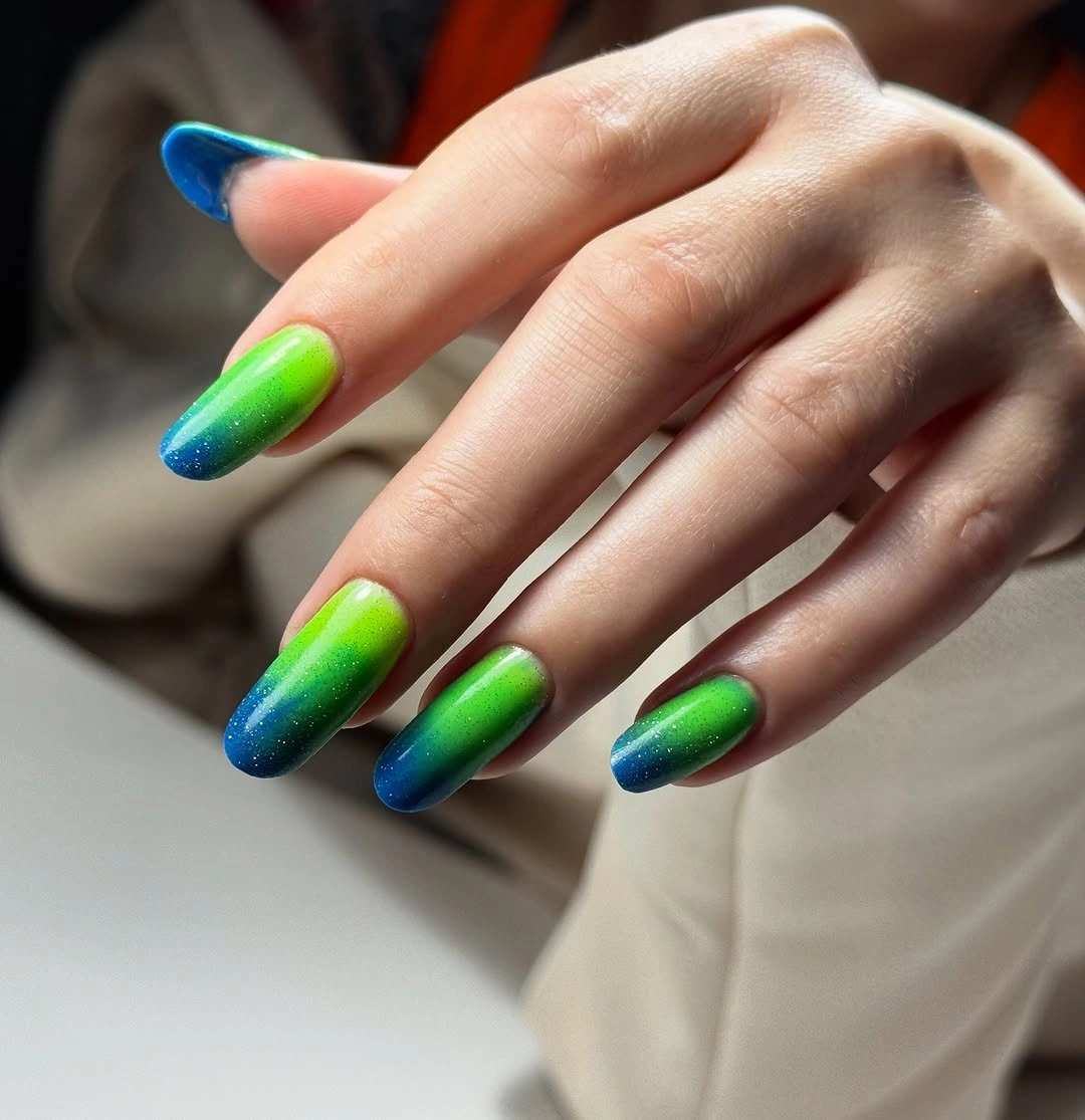 Long almond nails fading from lime green into blue tips