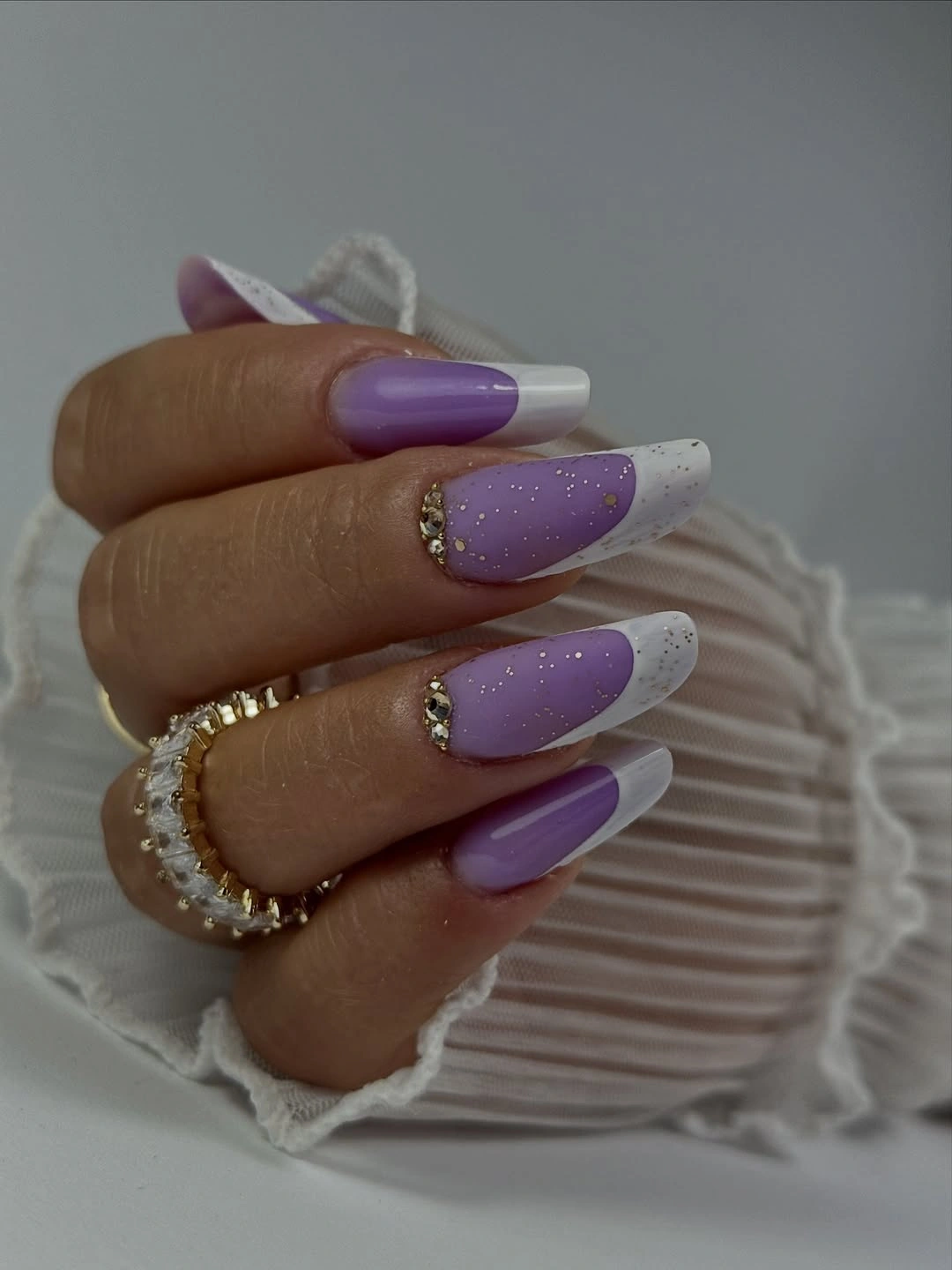 Long lavender nails with white French tips and tiny dark speckles