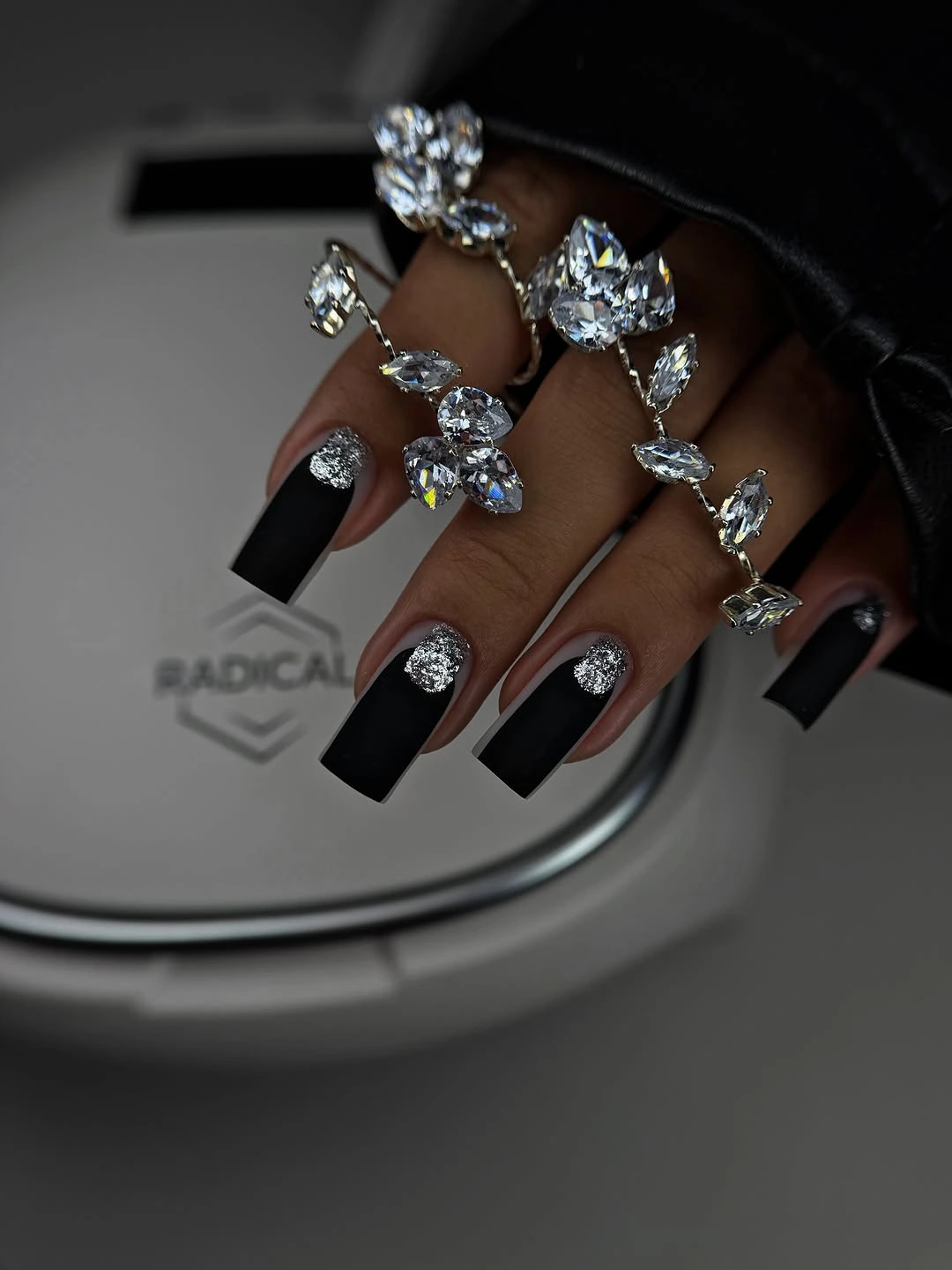 Long black square nails with silver glitter near the cuticles