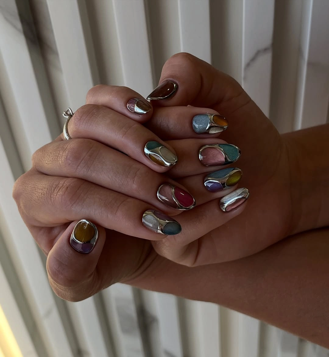 Short rounded nails with multicolor panels and silver chrome-like borders
