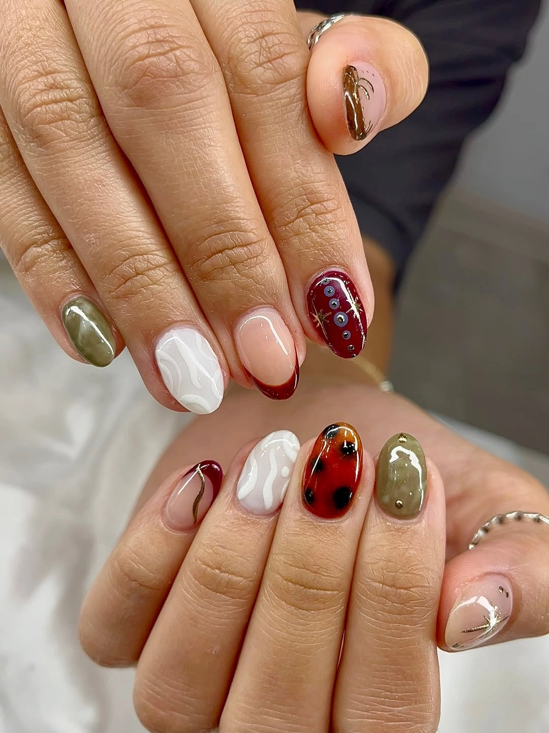 Short rounded nails with olive burgundy white and tortoiseshell-like accents