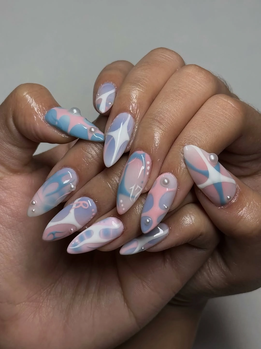 Long pointed nails with pastel swirls and pearl-like raised dots