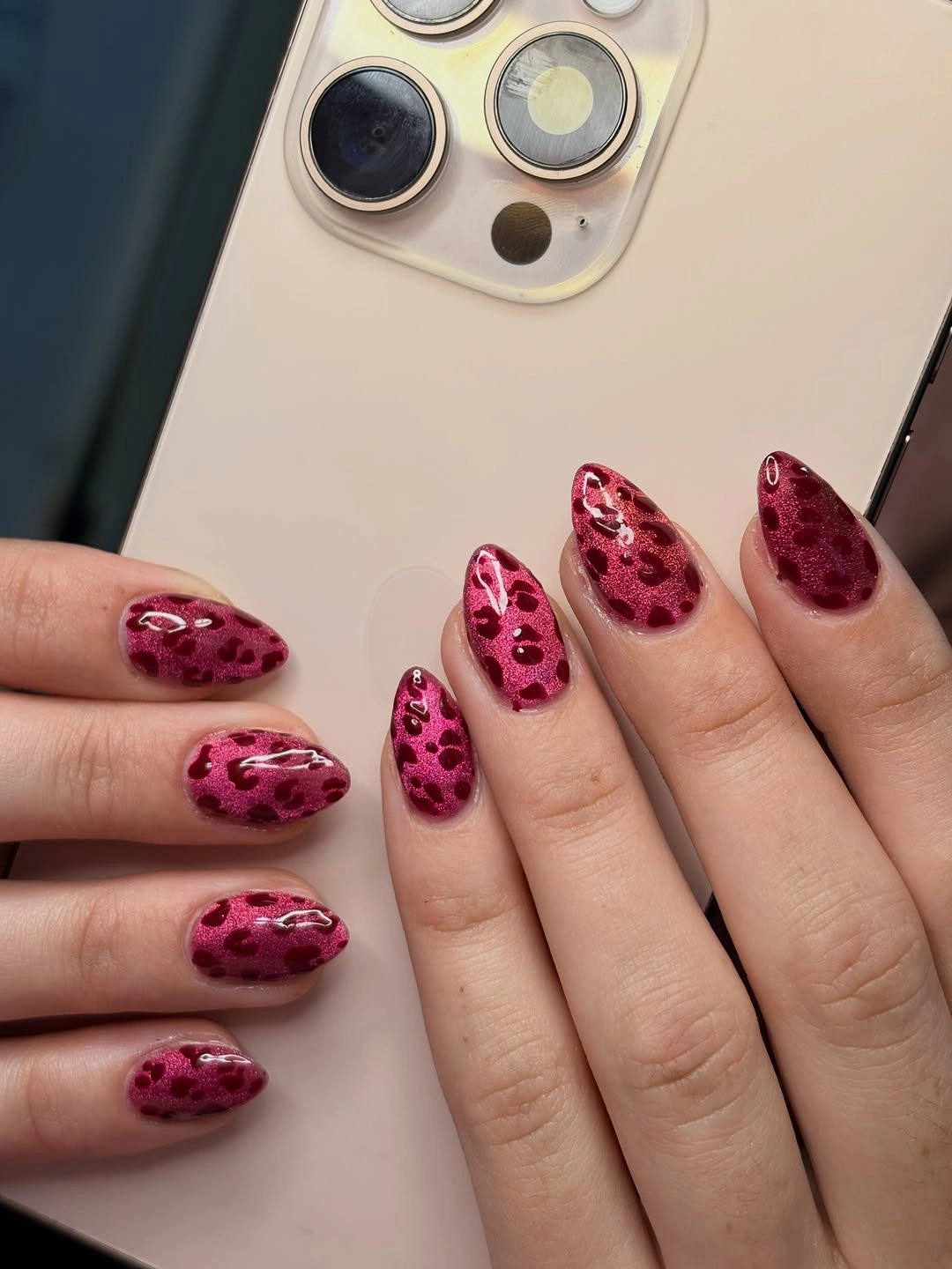 Almond nails with glossy pink base and magenta leopard-like spots