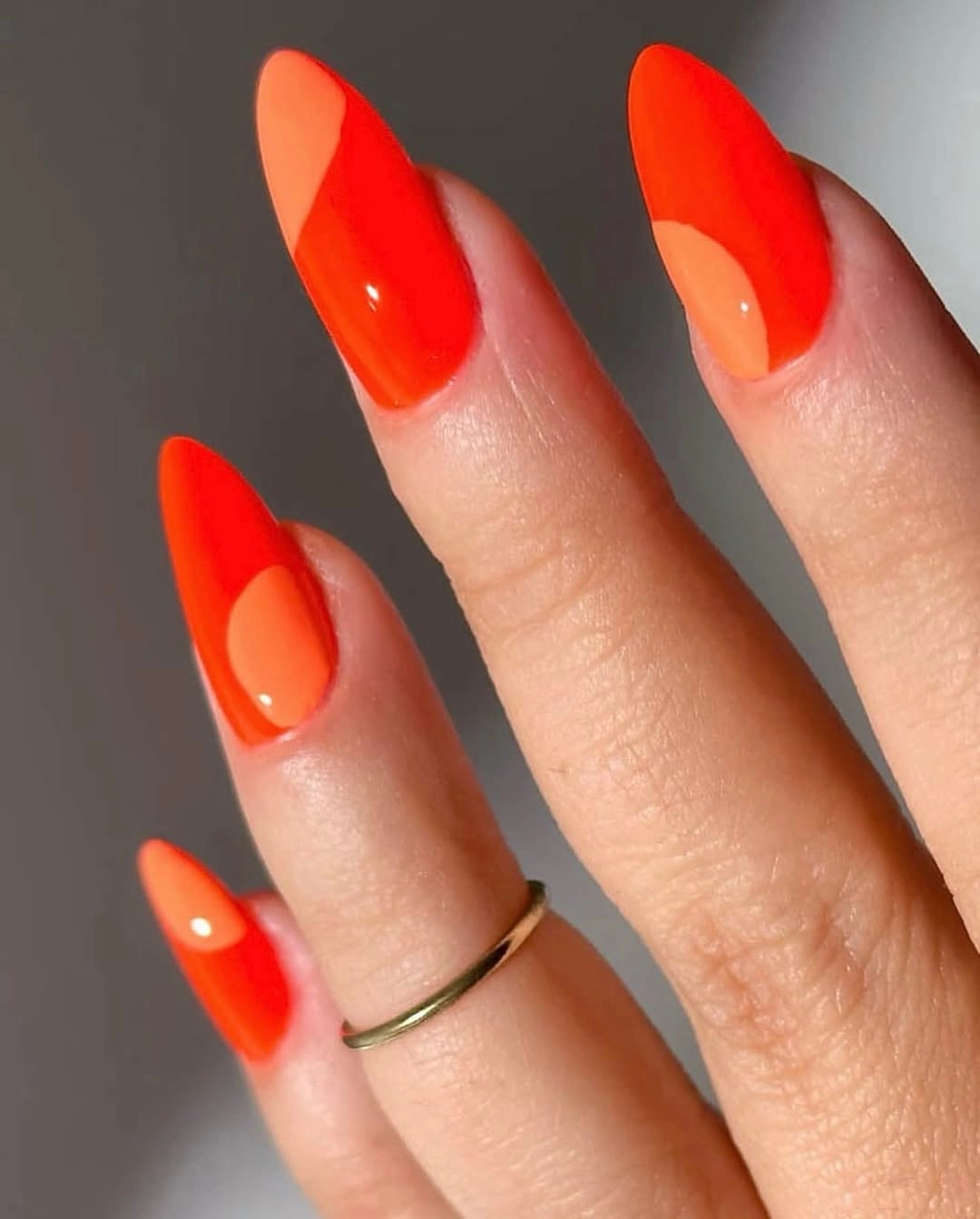 Long almond nails with vivid orange and peach curved color blocks