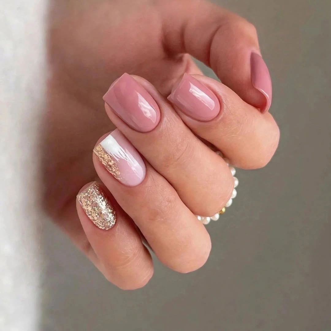 Short square nails with pink polish white stripe and gold glitter