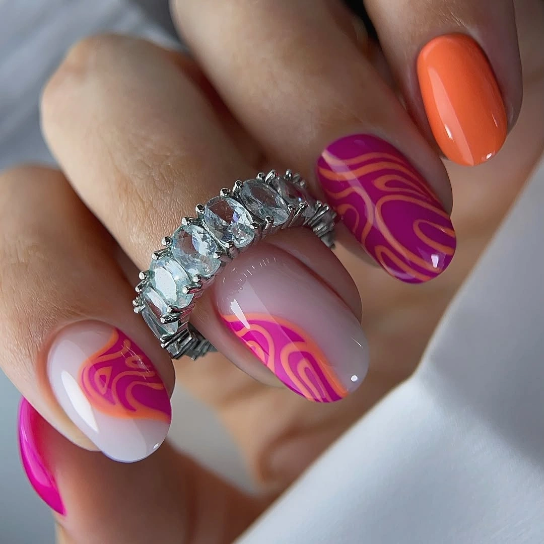 Short oval nails with orange pink white and magenta swirl details