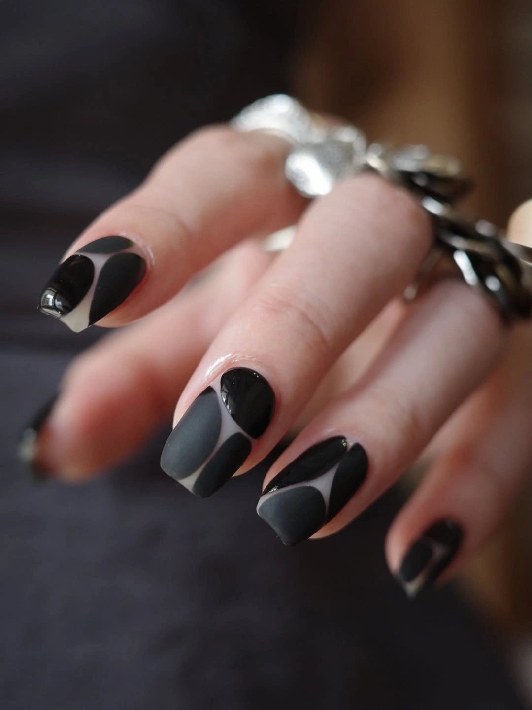 Squared nails with black gray curves and nude base spaces