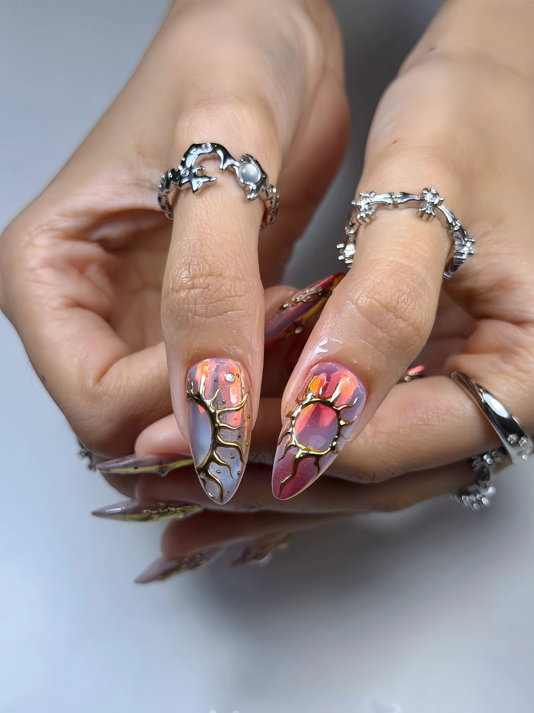 Long stiletto nails with multicolor fields and raised metallic-looking outlines