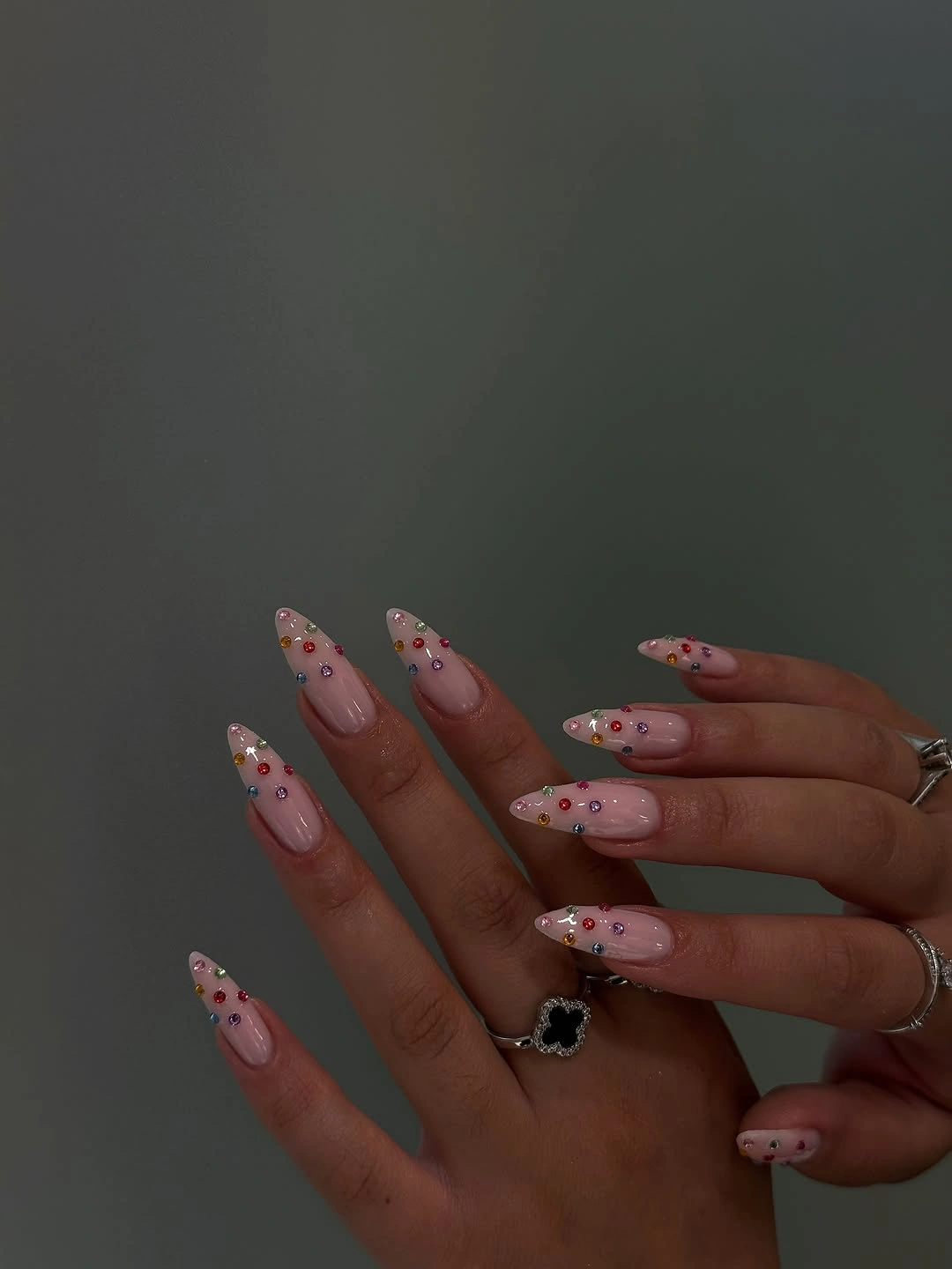 Long blush almond nails with tiny red and bright raised-looking dots