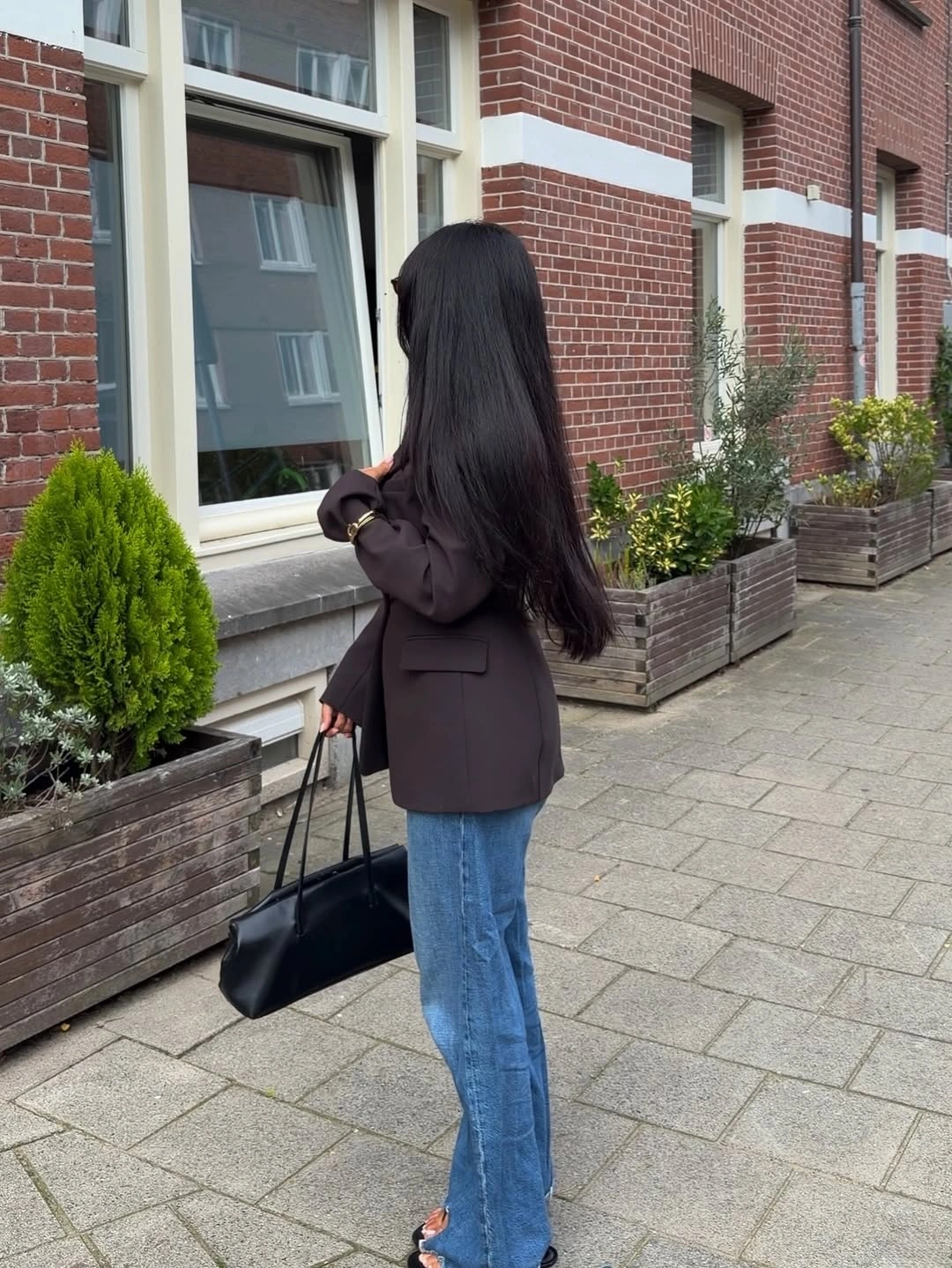 Dark oversized blazer, light blue jeans, and black shoulder bag