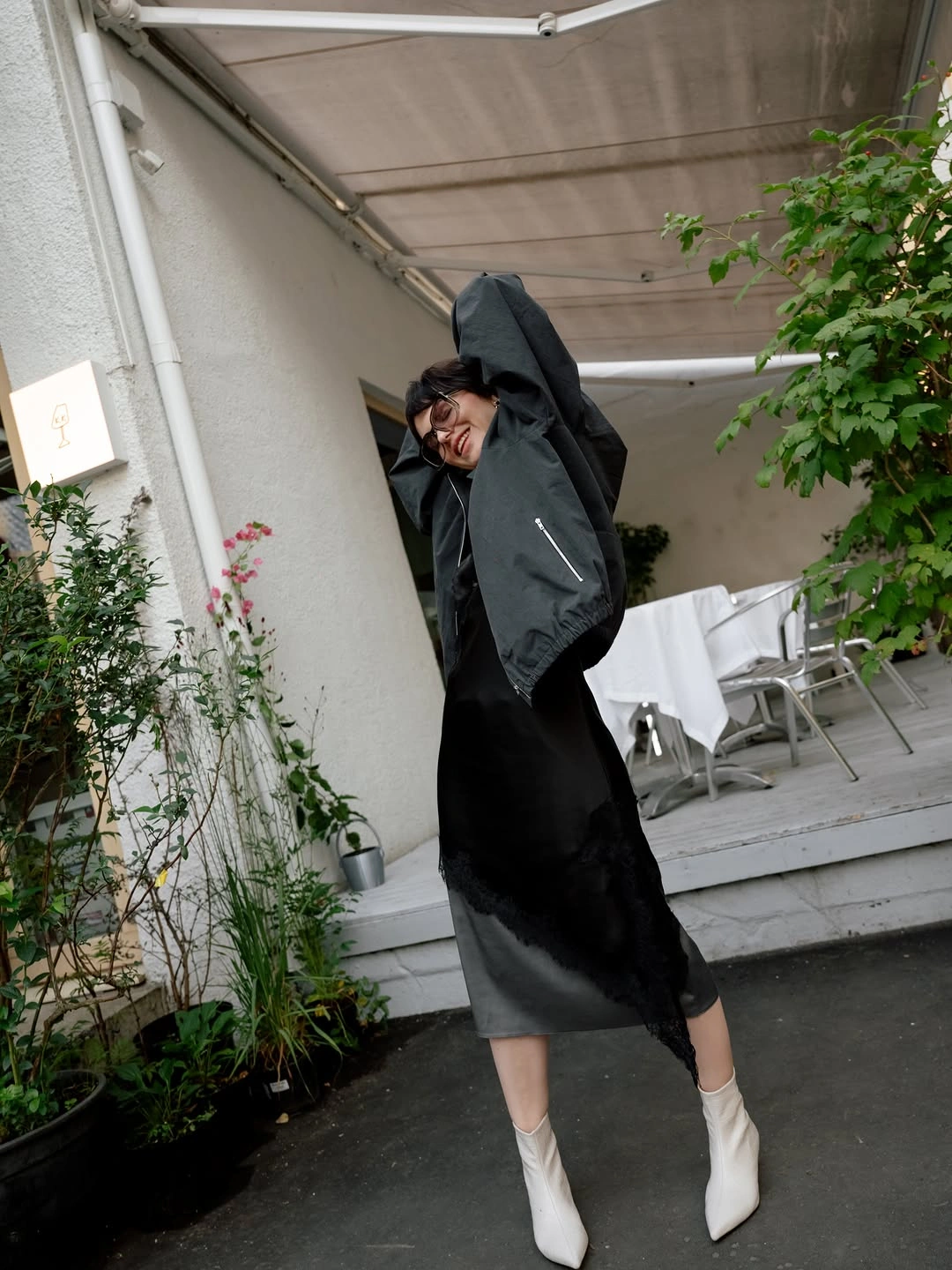 Dark column outfit with lifted jacket and white pointed boots