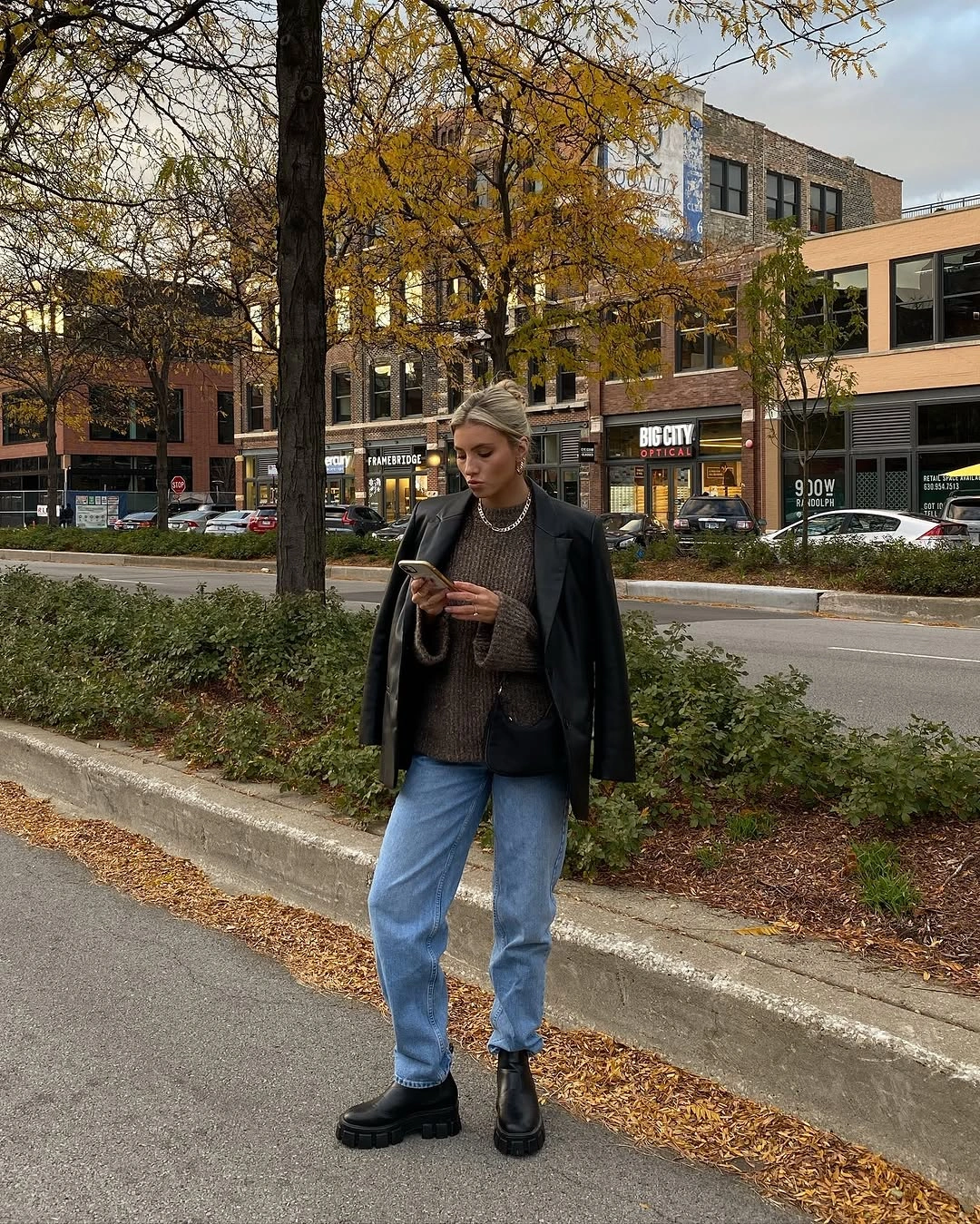 Black jacket, chunky brown knit, light jeans, and heavy black boots