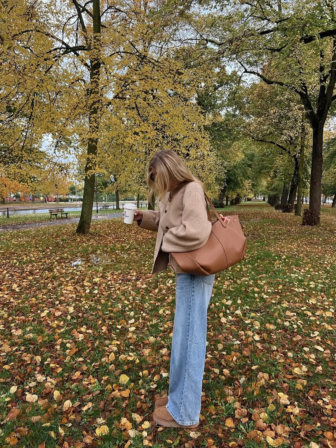 Beige cropped layer, light jeans, tan boots, and large tote