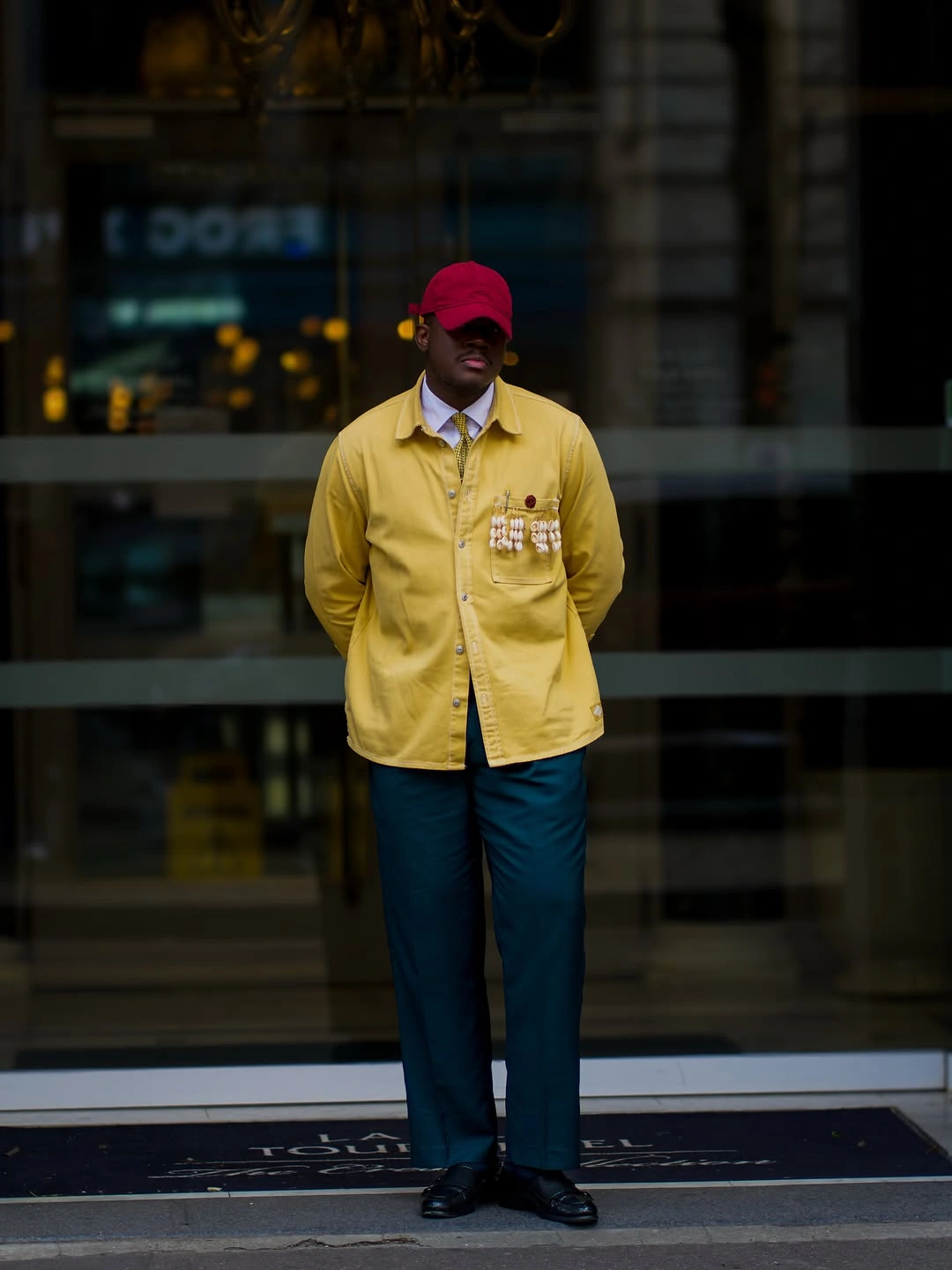 Loose navy shirt white trousers burgundy shoes and colorful bucket hat