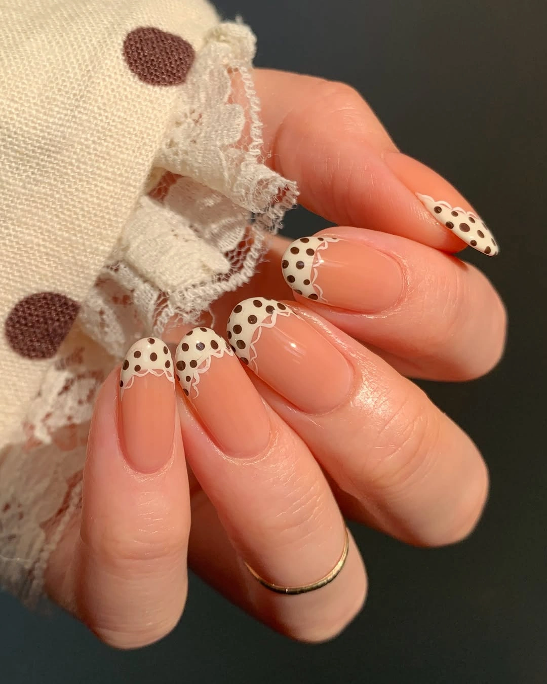 Long nude nails with white dotted tips and brown outline